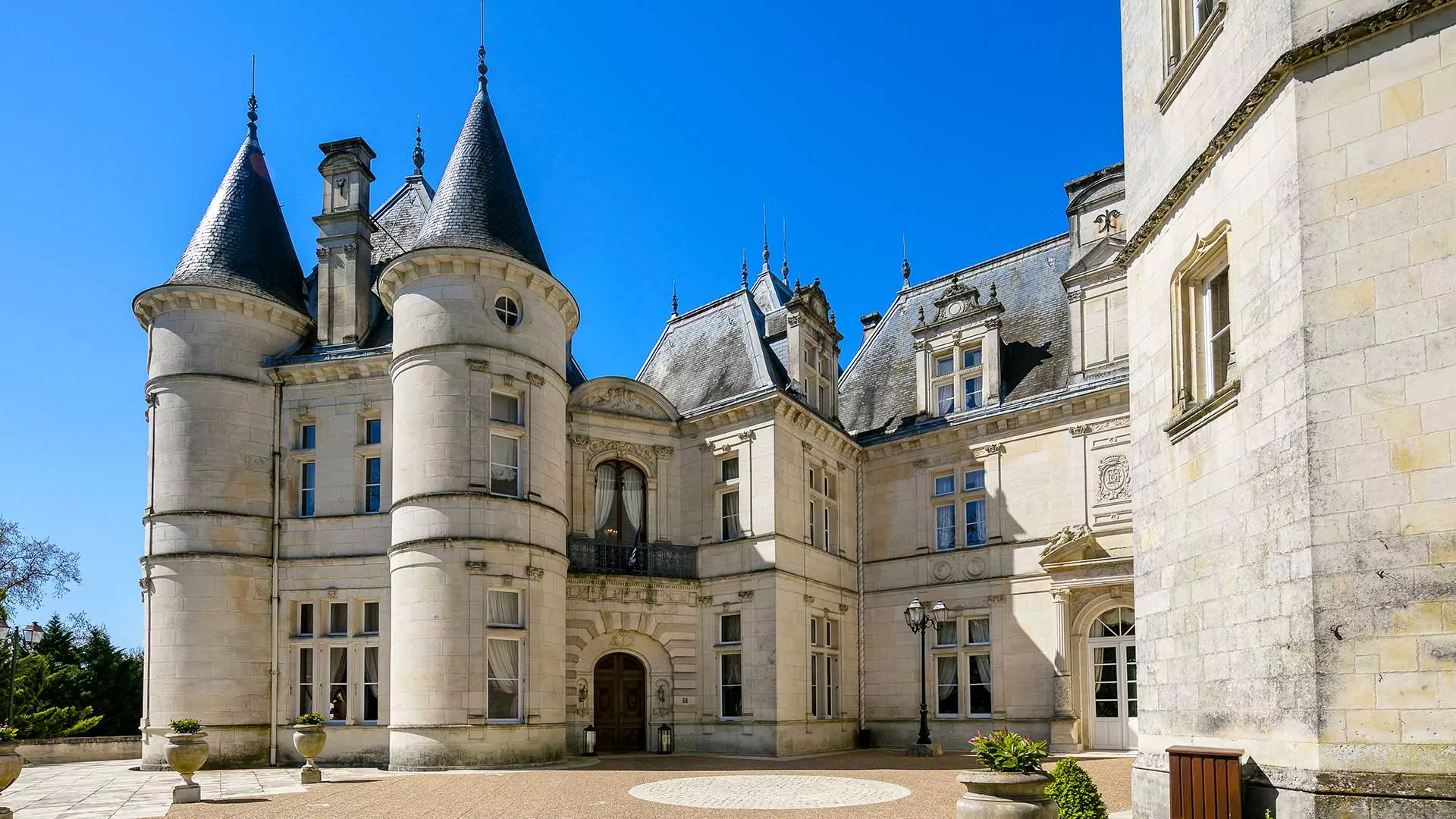Château Mirambeau Hauptfassade mit imposanten Rundtürmen und klassischer französischer Architektur